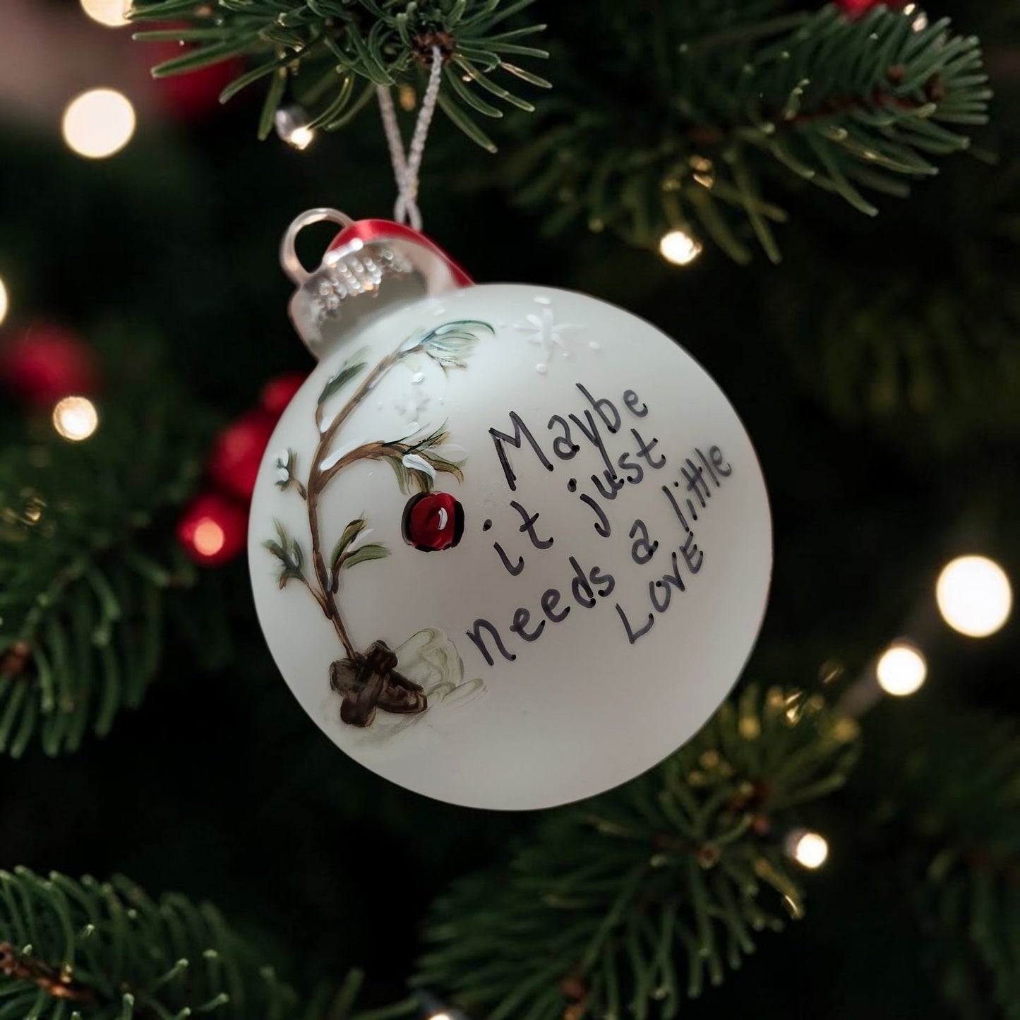 Handpainted glass Christmas ornament with snowy branch, red ornament and Maybe It Just Needs a Little Love message